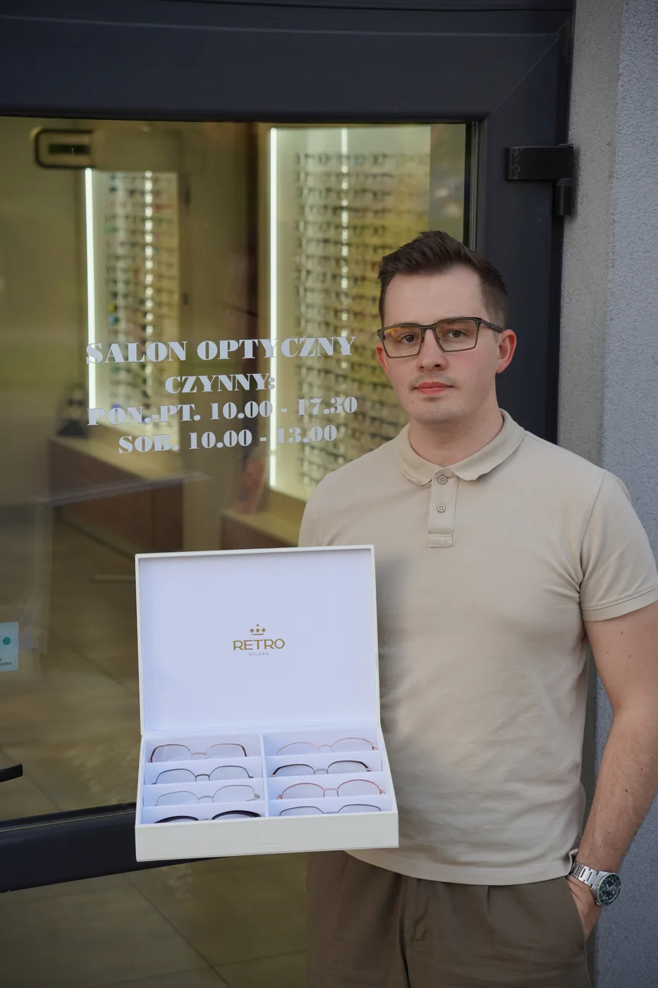 Igor Jatczak, optyk prowadzący salon Optyk Bryle, przed witryną salonu w Koluszkach